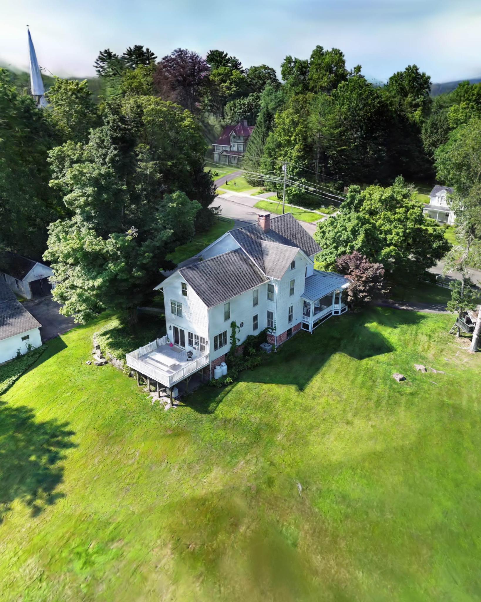 The Connecticut home featured in this seller’s story, surrounded by green lawns and mature trees.